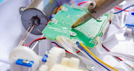 Soldering iron, tin, rosin. Soldering iron in male hands. Macro. Repair of electrical equipment,...