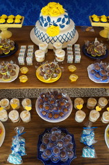 Floral cake with sweets. Blue, white and yellow colors. New house tea in portuguese. Bridal shower. Tradition just married.