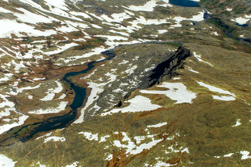 Mountain river valley. Mountains are covered with glaciers. View from helicopter flight altitude