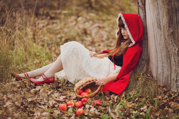 The girl in a red cape with a basket of apples. Snow White.