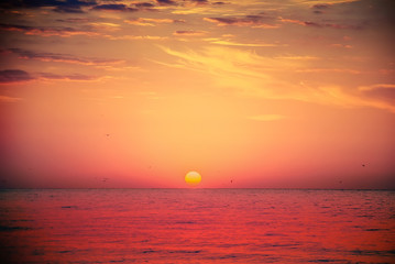 Beautiful vibrant red sunrise over the sea in summer