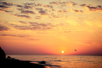 Beautiful sunrise or sunset over the sea coast with dramatic cloudy sky