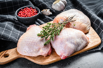 Raw chicken thigh, organic poultry meat. Black background. Top view