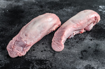 Raw pork tongue with spices and herbs. Black background. Top view