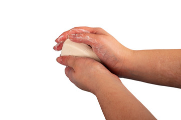 Someone is soaping their hands with a piece of toilet soap. Close up. Regular hand washing with soap is a prevention of COVID-19 infection. Isolate on a white background.