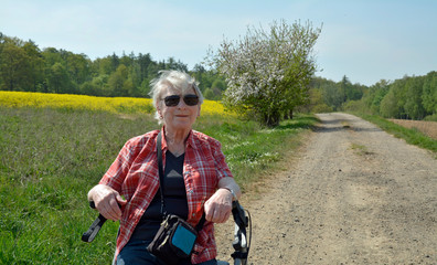 seniorin mit rollator auf feldweg