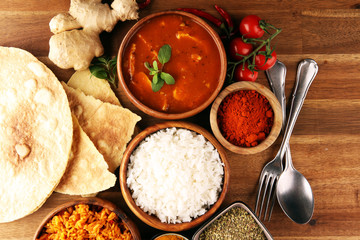 Chicken tikka masala spicy curry meat food in pot with rice and naan bread. indian food on table