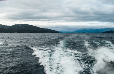 landscape from a boat in the sea, with background of mountains and snow