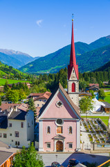 church with bell tower of the village in the middle of the green mountain valley