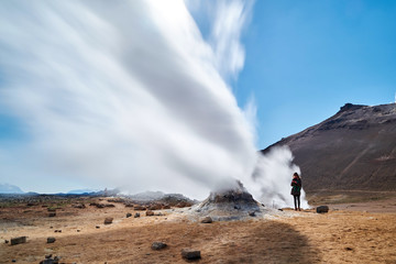 Woman Standing Next to Geothermal Rocks and Steam at Hverir, Namafjall, Iceland