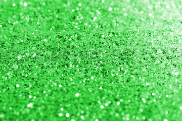 Fototapeta premium blurred green glitter texture festive abstract background, workpiece for design, soft focus