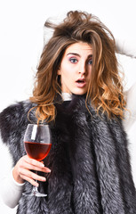 Fashion model long hair fur coat or vest hold wineglass. Luxury lifestyle concept. Fashionable lady...