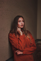 Portrait of a beautiful pensive woman in orange hoodie