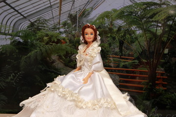 Fototapeta premium A small beautiful child's doll, posing in beautiful places. Queen. 