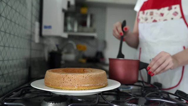 woman preparing carrot cake. Chocolate glaze pouring on homemade cake. Brazilian carrot cake. Topping chocolate on carrot cake. June Partys sweet
