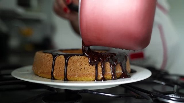 Chocolate icing on carrot cake. Chocolate glaze pouring on homemade cake. Brazilian carrot cake. Topping chocolate on carrot cake. June Partys sweet
