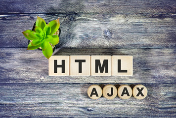 Fototapeta na wymiar AJAX HTML - text on wooden cubes, green plant in black pot on a wooden background
