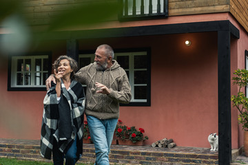 man and woman walking in the garden of their house