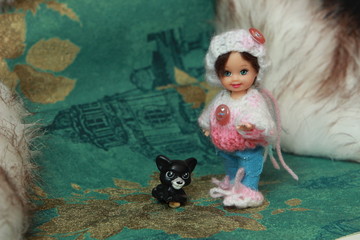 A small beautiful child's doll, posing in beautiful places. 