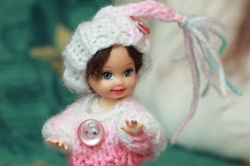 A small beautiful child's doll, posing in beautiful places. 