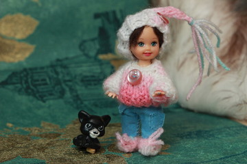 A small beautiful child's doll, posing in beautiful places. 