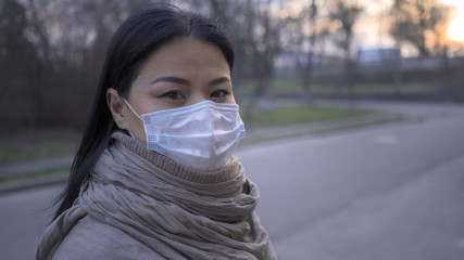 Asian Woman In Mask Stands On Empty City Street