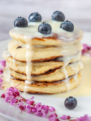 stacked pancakes with caramel syrup and blue berries