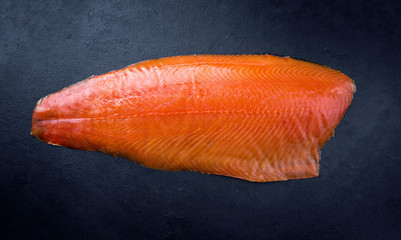 Traditional fresh graved salmon fillet offered as top view on a black board as background with copy...