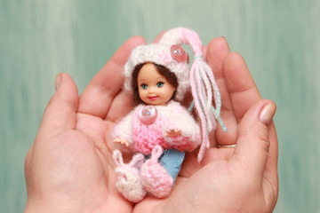 A small beautiful child's doll, posing in beautiful places. 