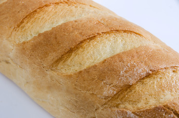 long loaf on a white background. Piece of loaf, bread texture. Close-up.