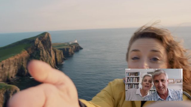 young travel woman video chatting with elderly parents blowing kiss sharing vacation in scotland having fun showing ocean