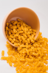 A small pile of gluten free corn pasta in plate on a white background.. Gluten Free Pasta