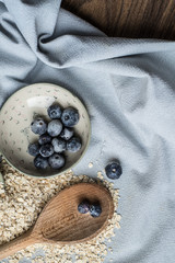 Breakfast cooking: oat and blueberries on blue fabric.