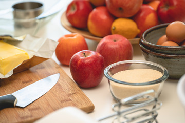 Baking apple pie. Apples, eggs, sugar, butter, and some ingredients close up on a kitchen table