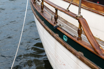 Port side of a vintage sailboat with mooring line, old ship rigging details, horizontal aspect