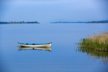 Fototapeta na wymiar Fishing boat in blue lake Golyazi Village of Turkey