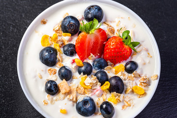 Yogurt with granola, strawberries and blueberries.