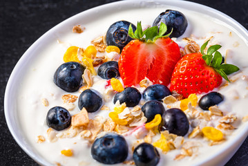 Yogurt with granola, strawberries and blueberries.