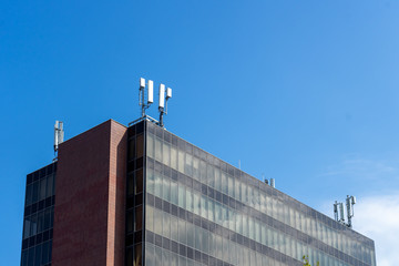 Obraz premium A modern office block with 5G antennas on top of it