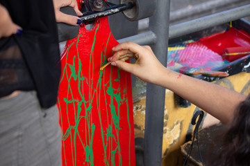 woman painting a skateboard with green paint © Gabriel Kern