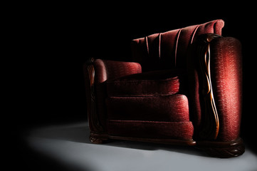 Dramatic red arm chair on black background
