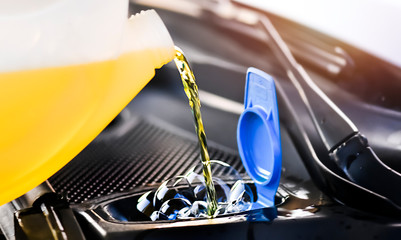 Pouring summer liquid or yellow car fluid for washing car screen