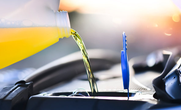 Pouring summer liquid or yellow car fluid for washing car screen