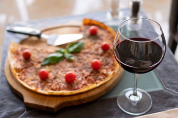 pizza with cherry tomato, sauce and glass of wine