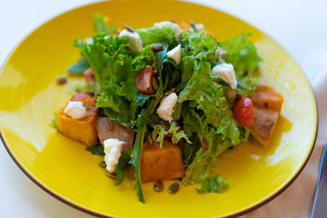 salad with baked vegetables, herbs, nuts and kerm cheese