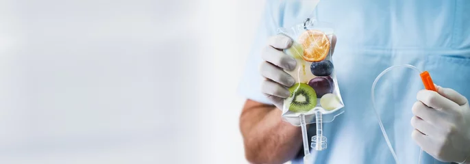 Fotobehang Doctor Holding Saline Bag With Fruit Slices Inside In Hospital © Andrey Popov