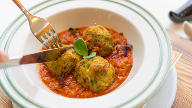 vegetable noisettes in tomato sauce. Cuts with a knife and fork. Closeup top view