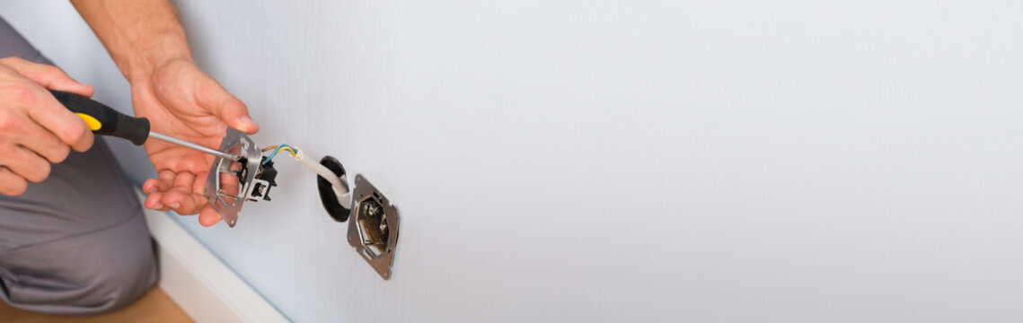 Electrician Hands Installing Wall Socket