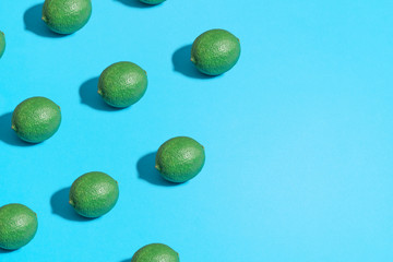 Minimal flat lay food texture. Summer abstract trendy fresh concept. Lime pattern on bright light blue background, copy space.