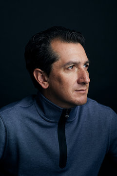 Close up portrait of a man over a black background.
